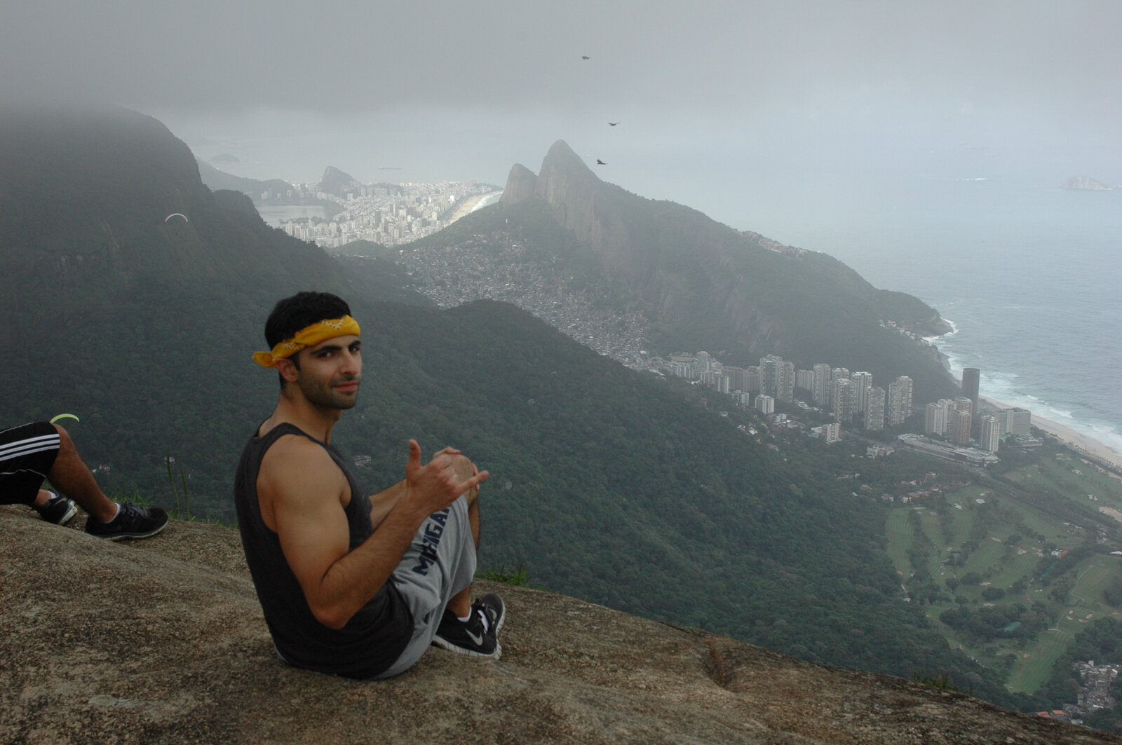 Dr. Matar resting on a mountain summit above the coastline after a hike